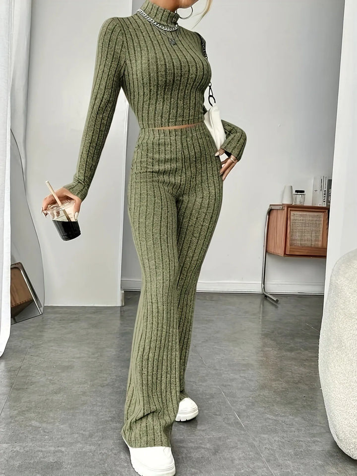 Woman wearing army green ribbed knit crop top and flare pants set, walking