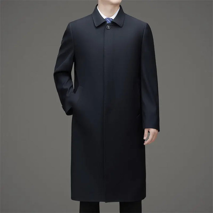 Man wearing navy blue long trench coat buttoned, front view
