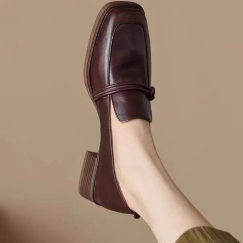 Side view of brown knotted strap loafer on foot