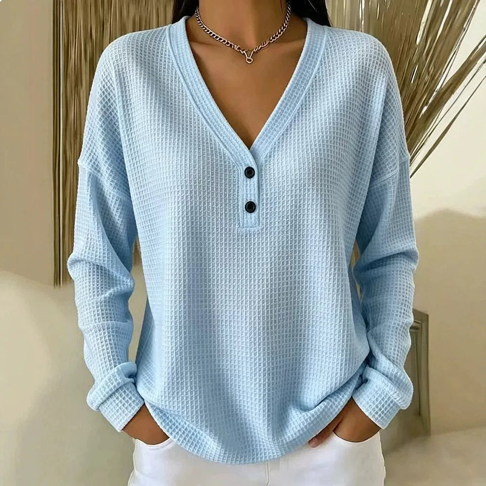 Woman wearing sky blue waffle knit V-neck henley top with button placket
