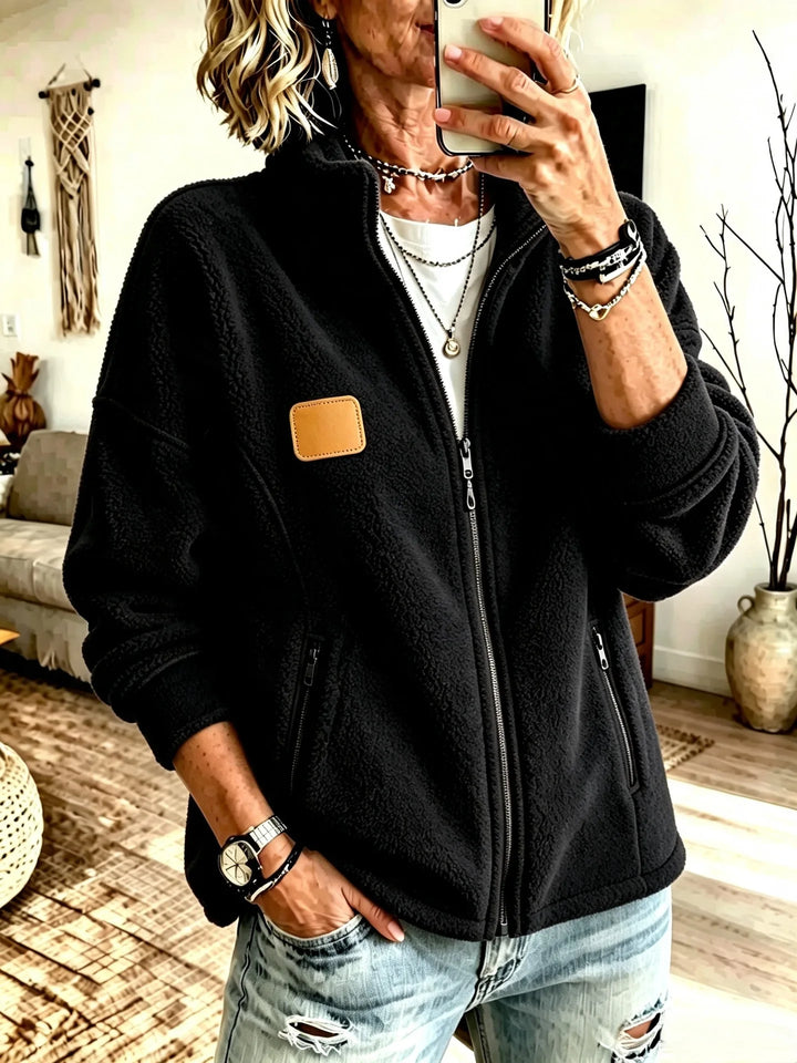 Woman wearing black fleece full zip jacket with zippered pockets
