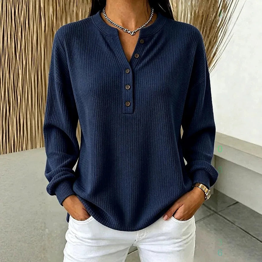 Woman wearing dark blue ribbed knit henley top with button placket