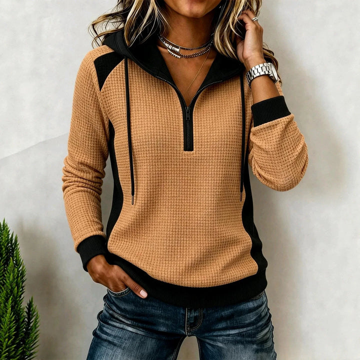 Woman wearing khaki waffle knit half zip hoodie with black contrast panels