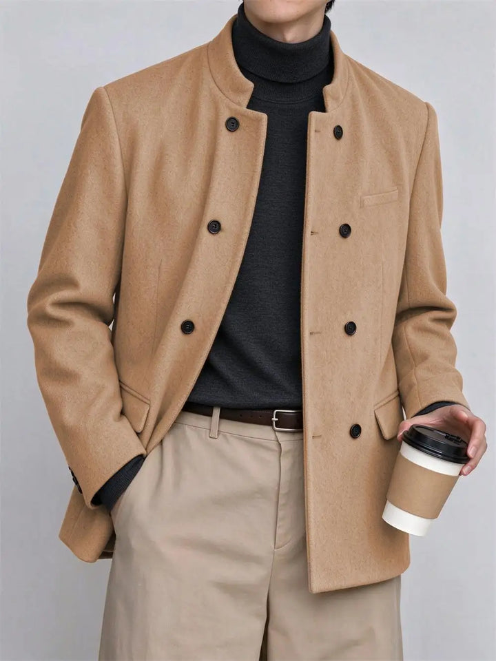 Man wearing camel mandarin collar coat holding coffee