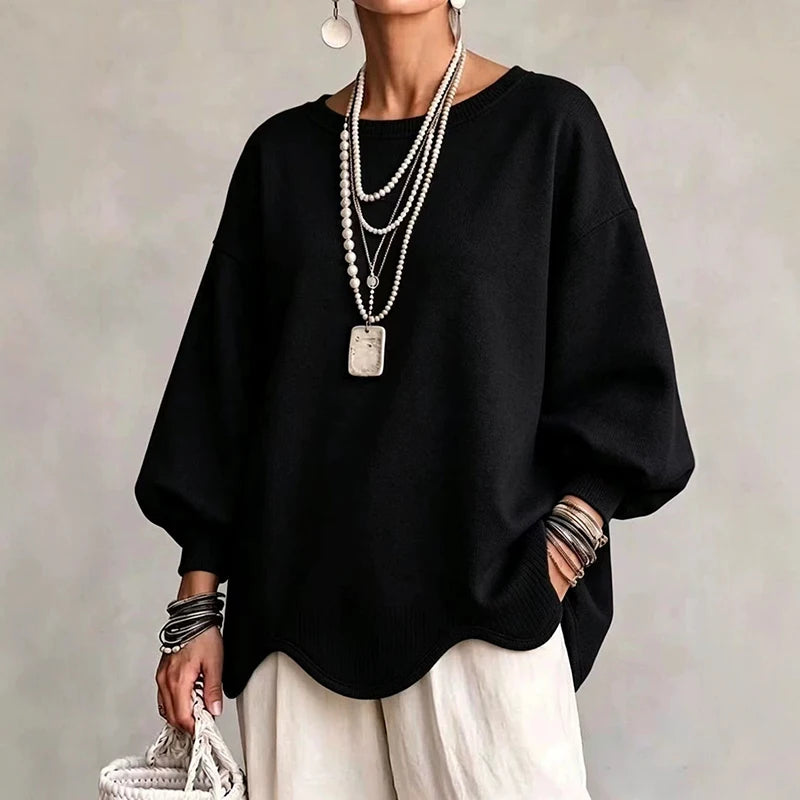 Woman wearing black oversized sweatshirt with wavy hem