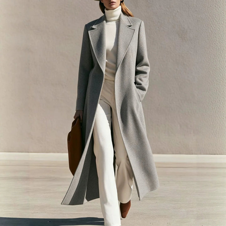 Woman wearing long gray wool-blend coat with notched lapel walking outdoors