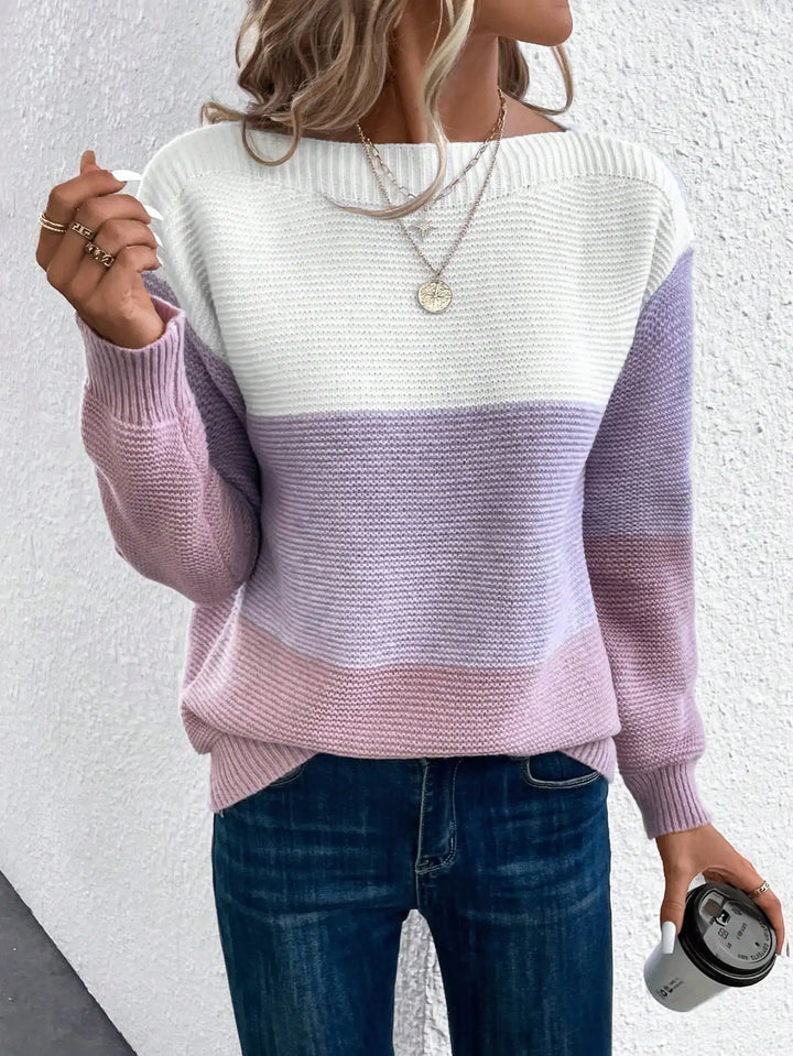 Woman wearing lavender and pink color block knit sweater, front view