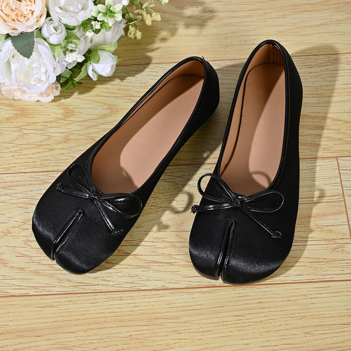 Black satin ballet flats top view with bow