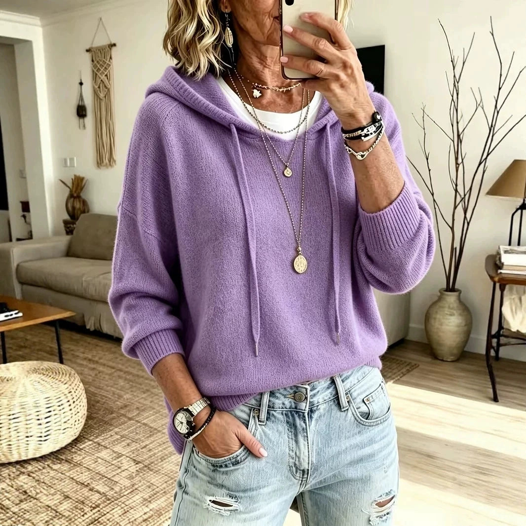 Woman wearing purple knit drawstring hoodie with jeans, front view