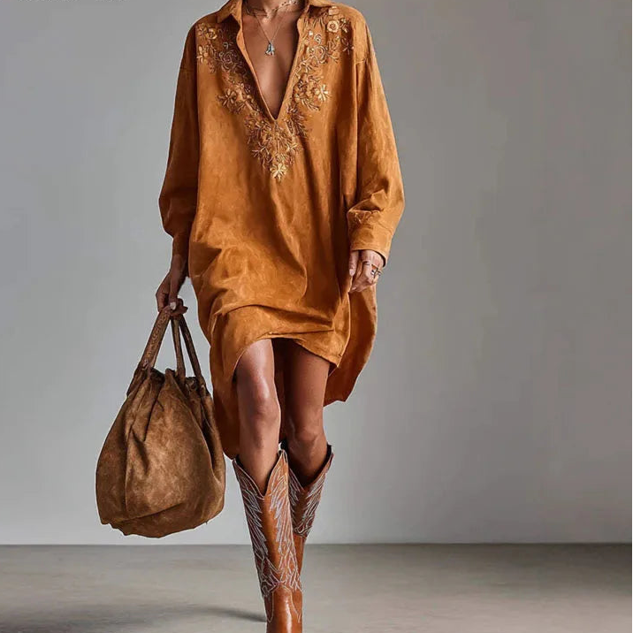 Woman wearing rust orange embroidered V-neck shirt dress, front view