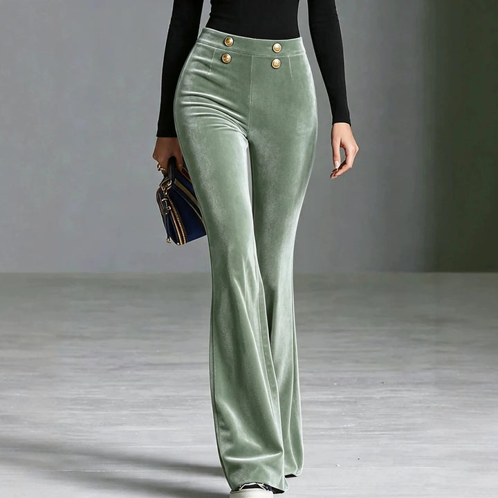 Woman wearing light green velvet flared high waist pants with gold buttons, front view