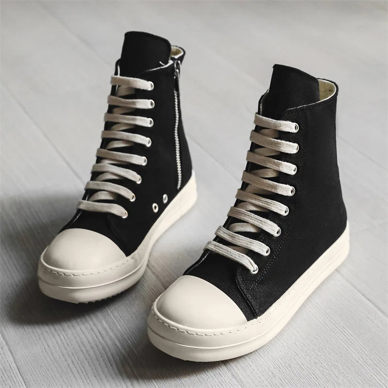 Black canvas high top sneakers with side zip and thick sole, side angle pair