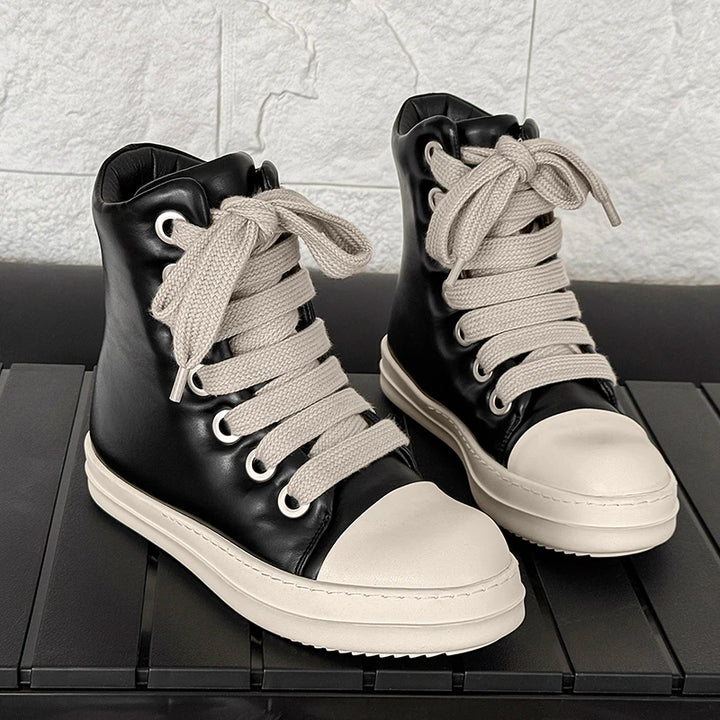 Pair of black high top sneakers with white platform soles and rope laces on display