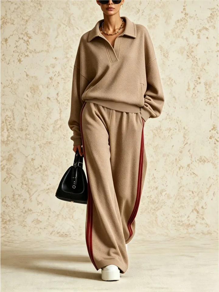 Woman wearing khaki two piece collared sweatsuit with red side stripe pants