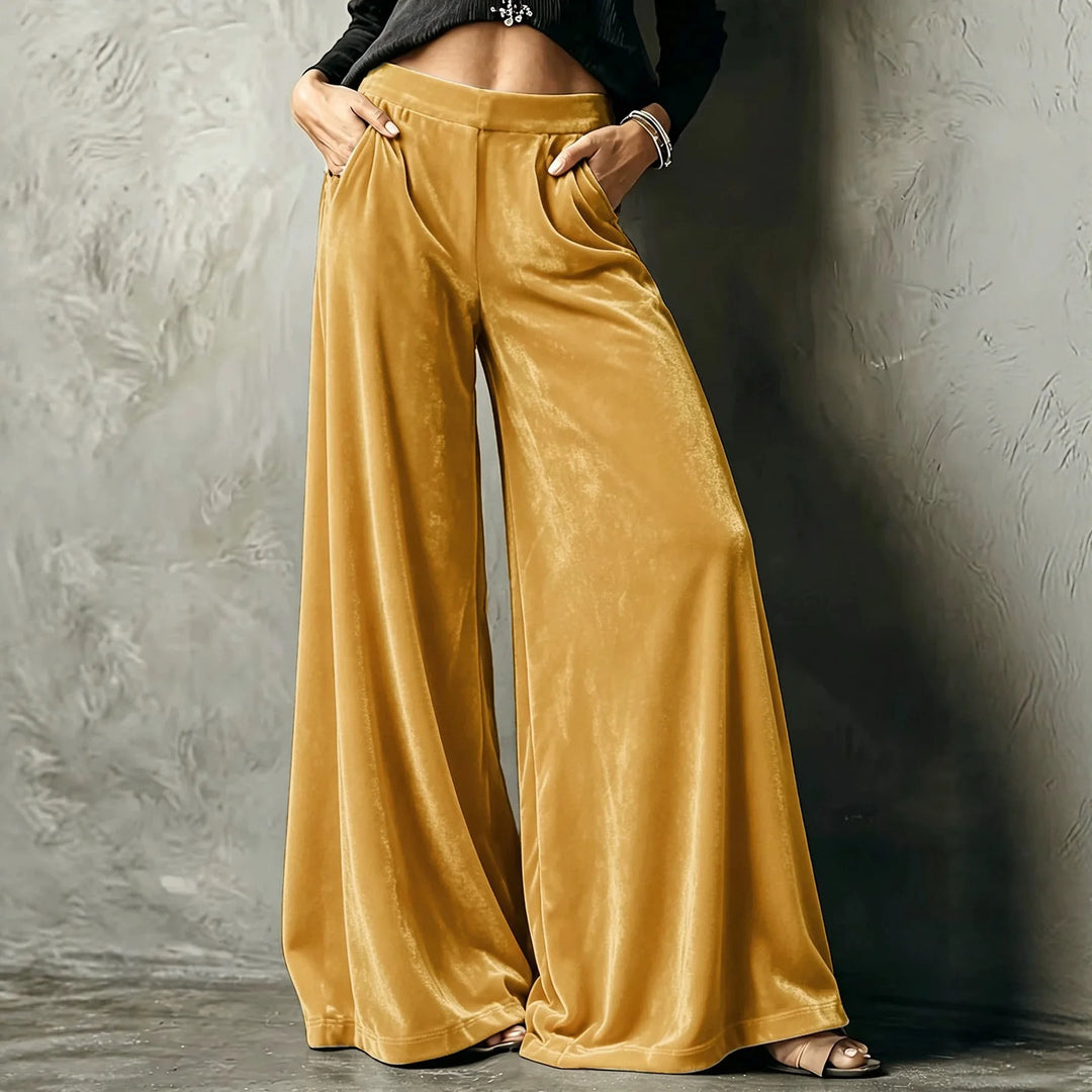 Woman wearing yellow velvet wide leg pants with hands in pockets