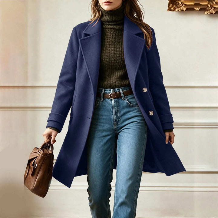 Woman walking in navy blue double-breasted wool coat carrying a bag