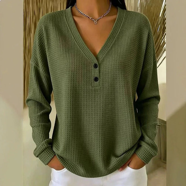 Woman wearing army green waffle knit V-neck henley top with button placket