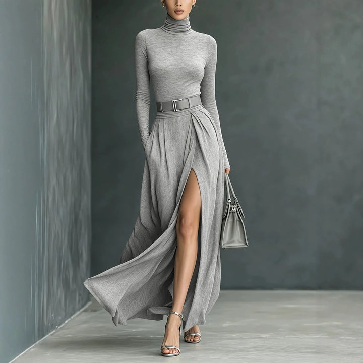 Woman wearing gray turtleneck sweater dress with high slit, front view