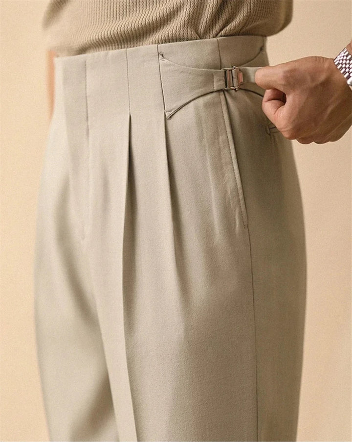 Close up of beige trousers with side tab buckle detail