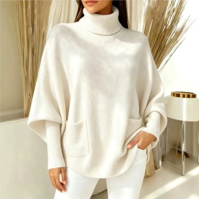 Woman wearing cream turtleneck batwing sweater with front pocket