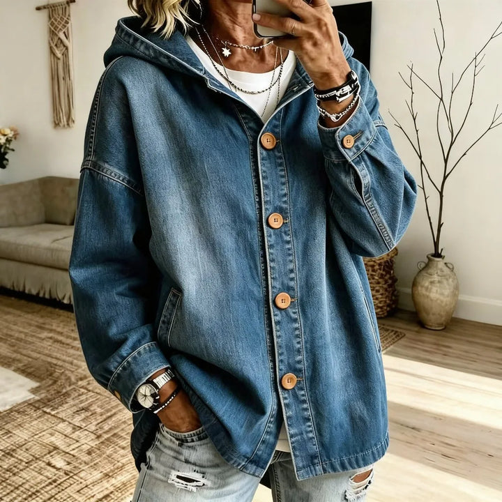 Woman wearing oversized hooded denim jacket in medium wash with wood buttons