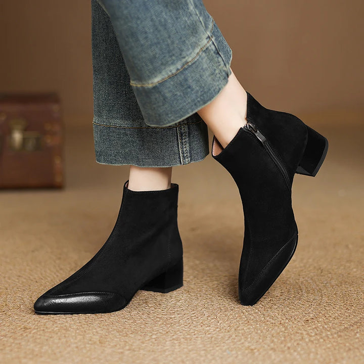 Model wearing black suede pointed toe ankle boot with side zip