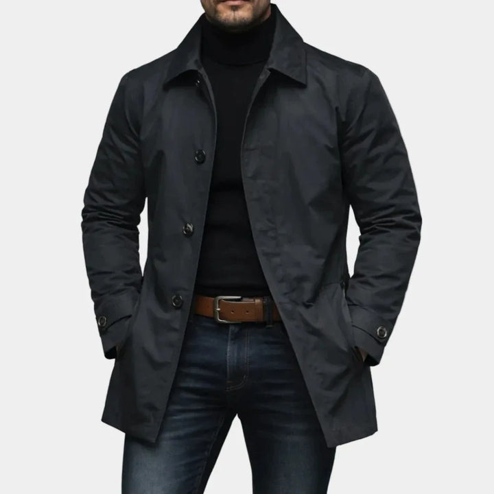 Man wearing black mac-style trench coat with button front