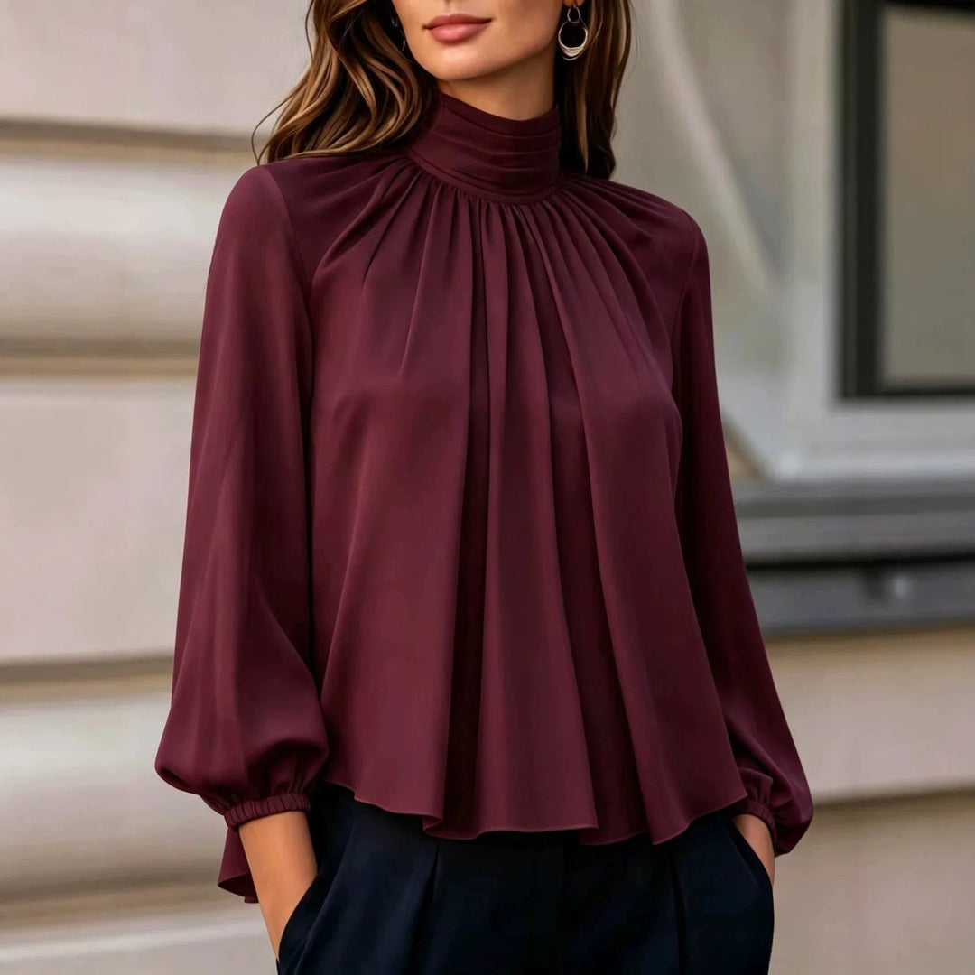 Woman wearing burgundy pleated mock neck blouse with bishop sleeves