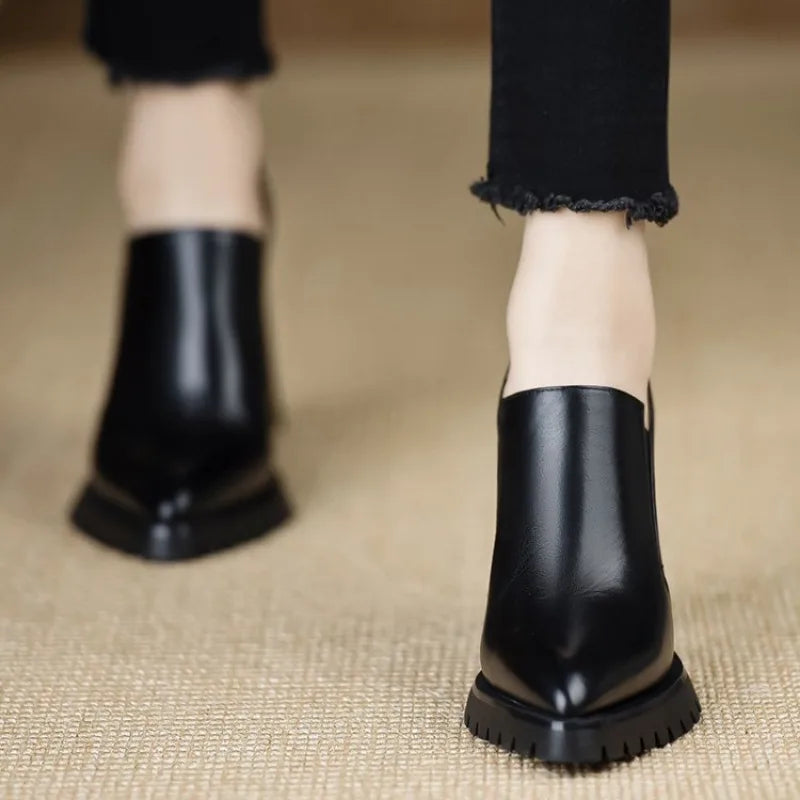 Black leather pointed toe pumps, front walking view