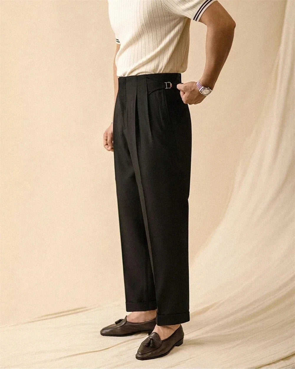 Man wearing black pleated trousers with loafers, side view