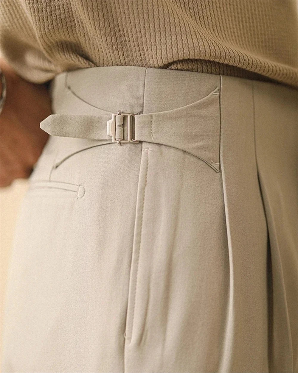 Detail of side buckle closure on sage grey trousers