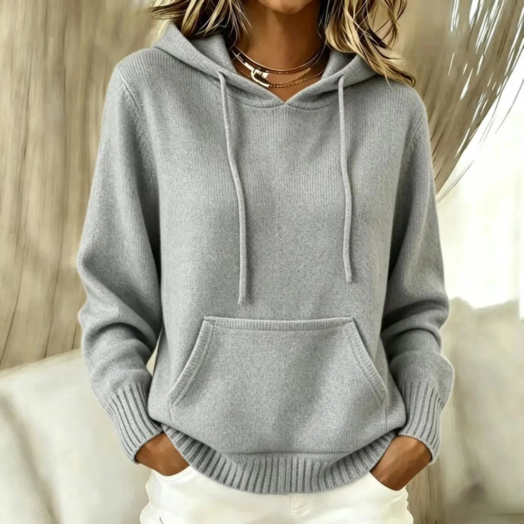 Woman wearing gray hooded knit sweater with kangaroo pocket