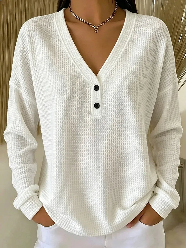 Woman wearing white waffle knit V-neck henley top with button placket