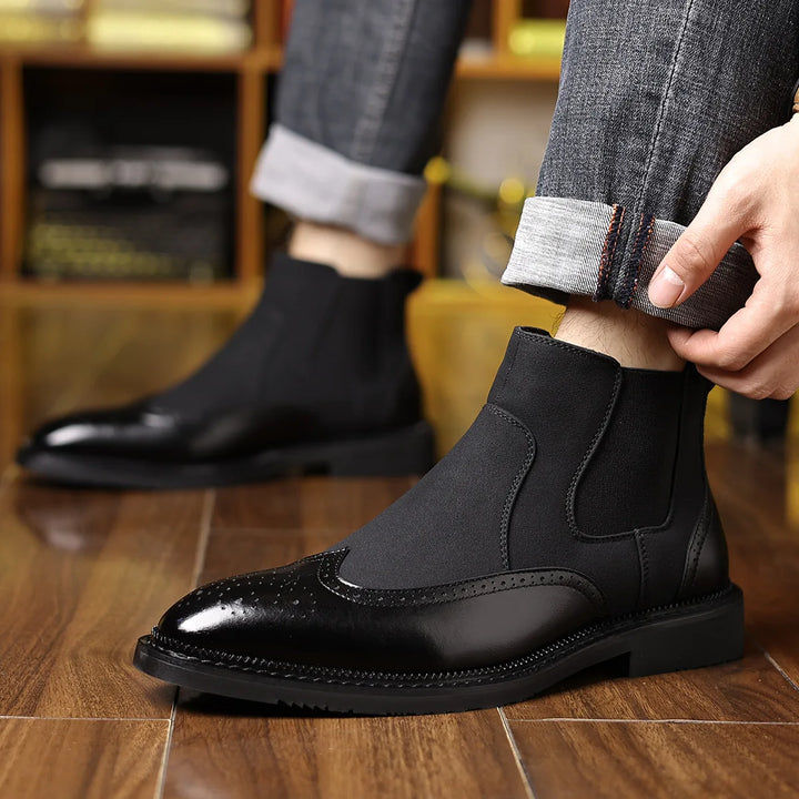 Man wearing black Chelsea boots with cuffed jeans