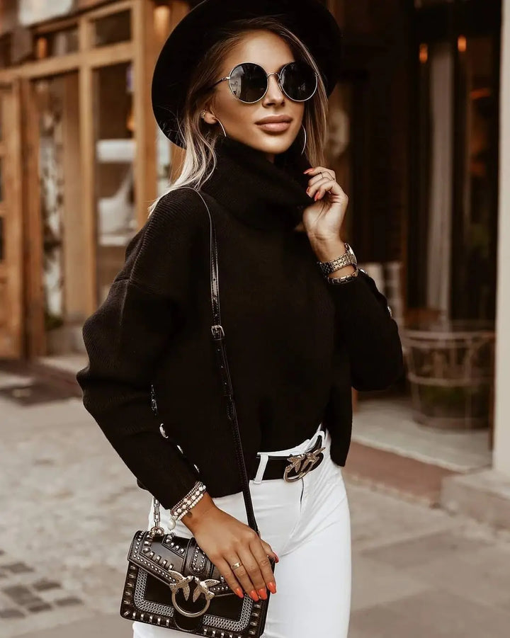 Woman wearing black turtleneck sweater with button cuff detail