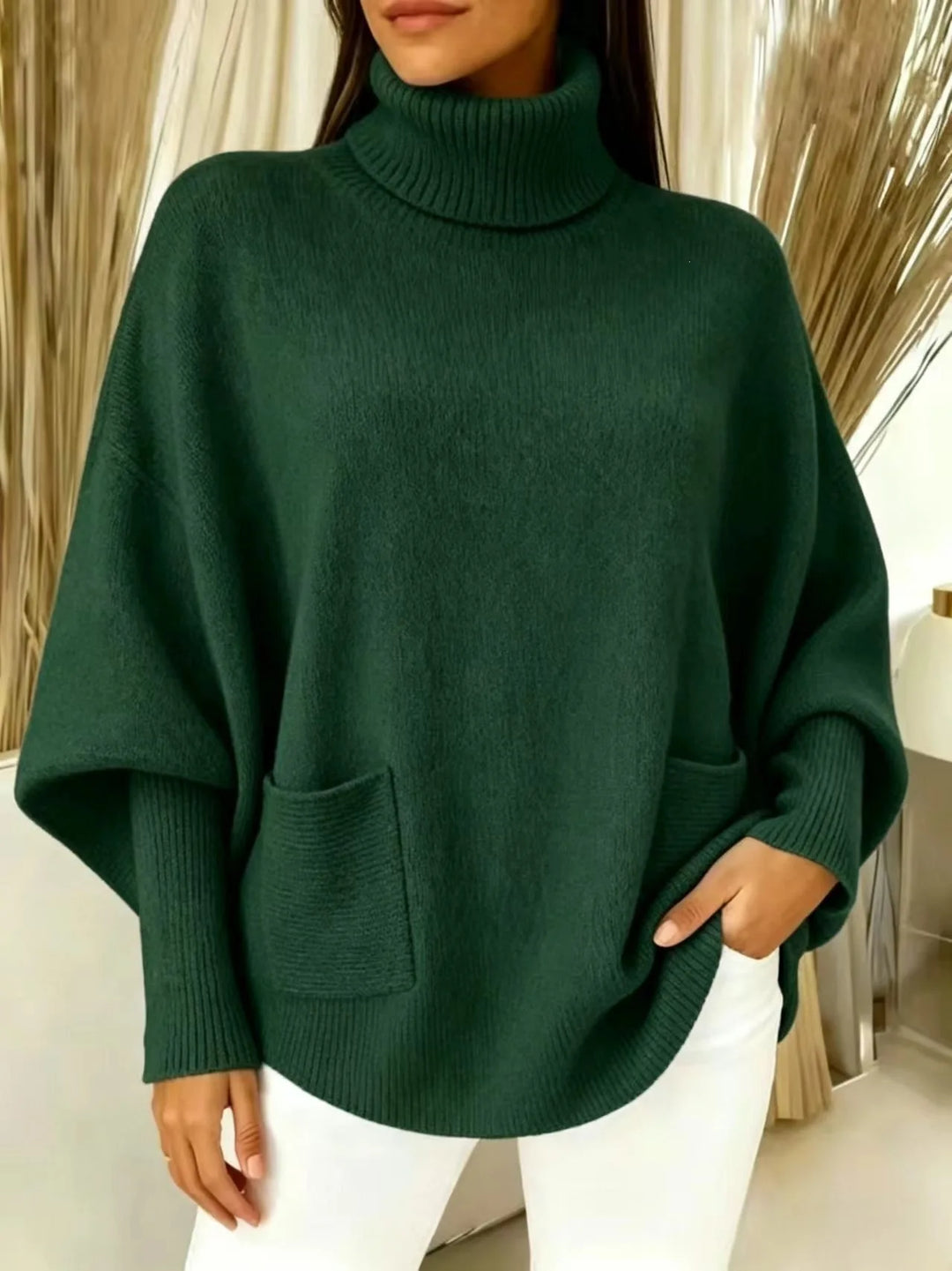 Woman wearing dark green turtleneck batwing sweater with front pocket