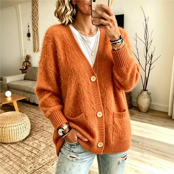 Woman wearing orange sequin eyelash-knit cardigan with pockets