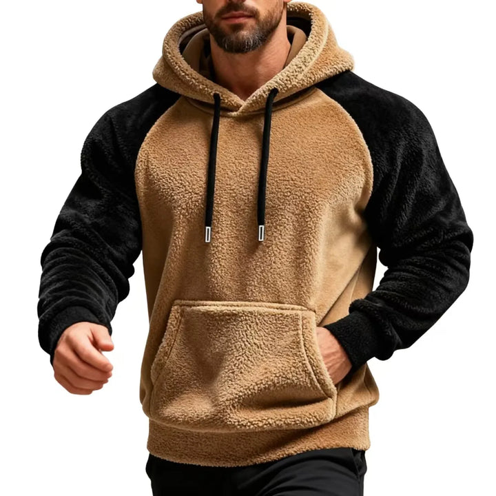 Man wearing khaki and black sherpa fleece hoodie with drawstring hood and kangaroo pocket