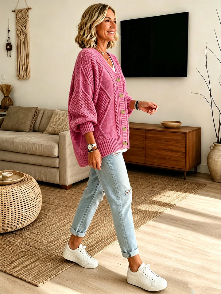 Pink cable knit cardigan worn with jeans, side view walking