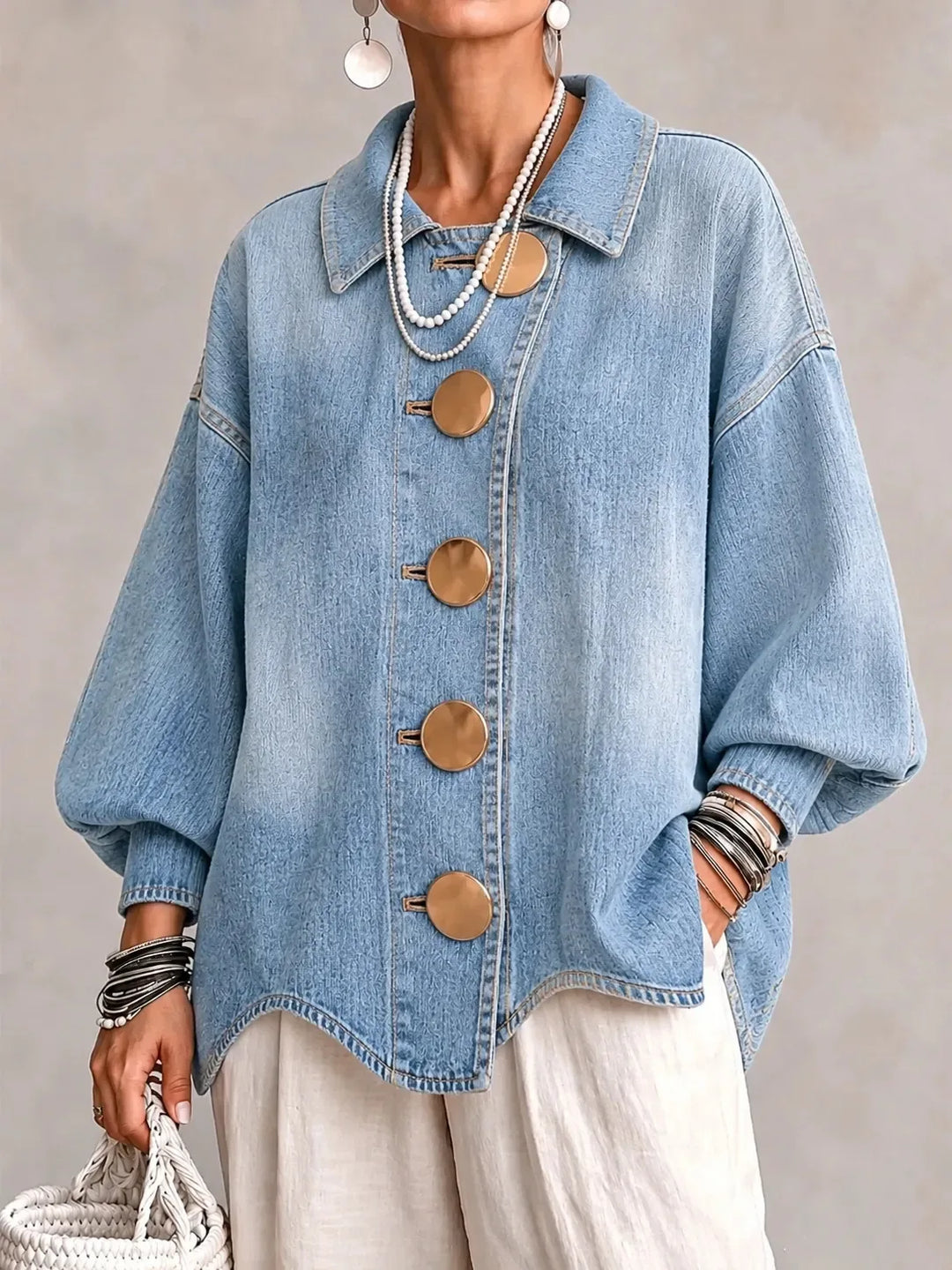 Woman wearing sky blue denim jacket with large gold buttons, front view