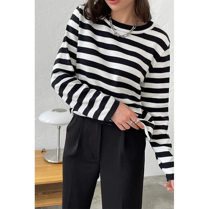 Woman wearing black and white striped knit sweater with necklace