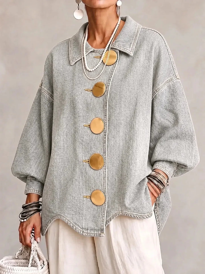 Woman wearing light gray denim jacket with large gold buttons, front view