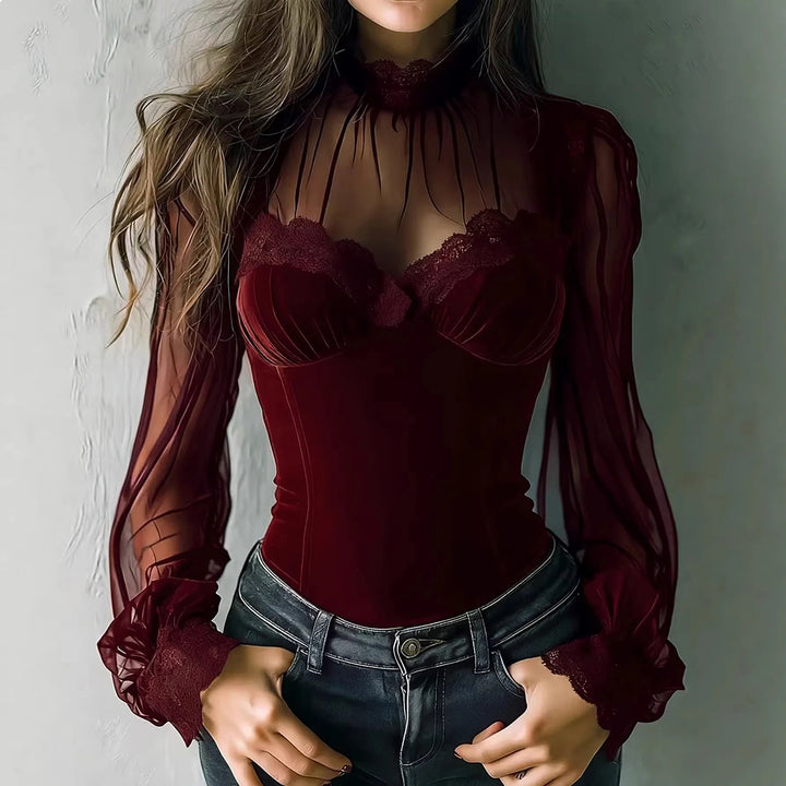 Woman wearing burgundy velvet top with sheer lace sleeves