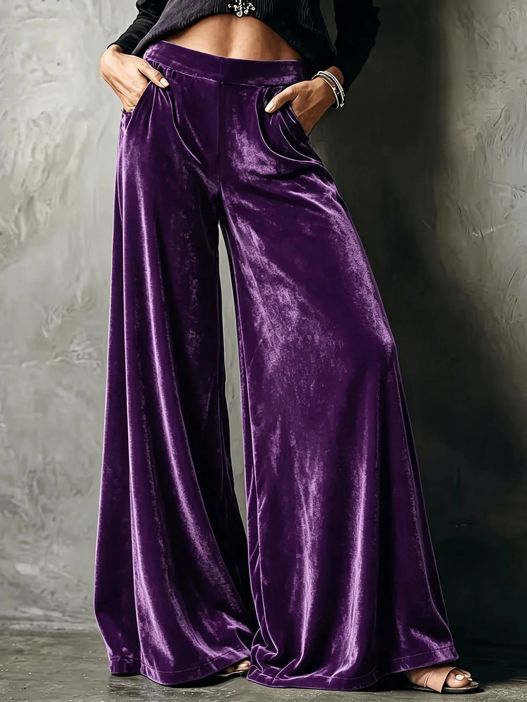 Woman wearing purple velvet wide leg pants with hands in pockets
