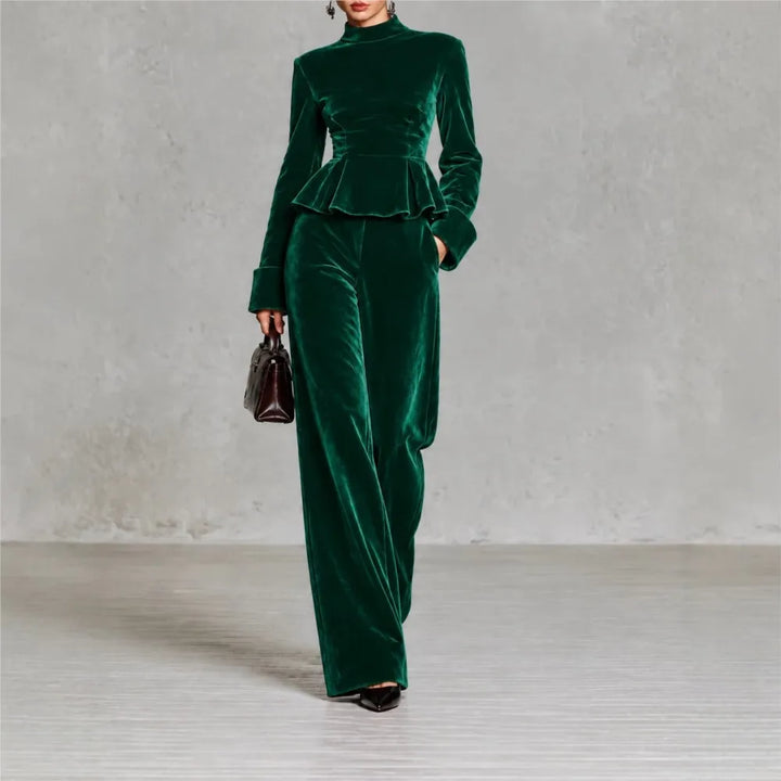 Woman wearing green velvet peplum top and wide leg pants set, front view