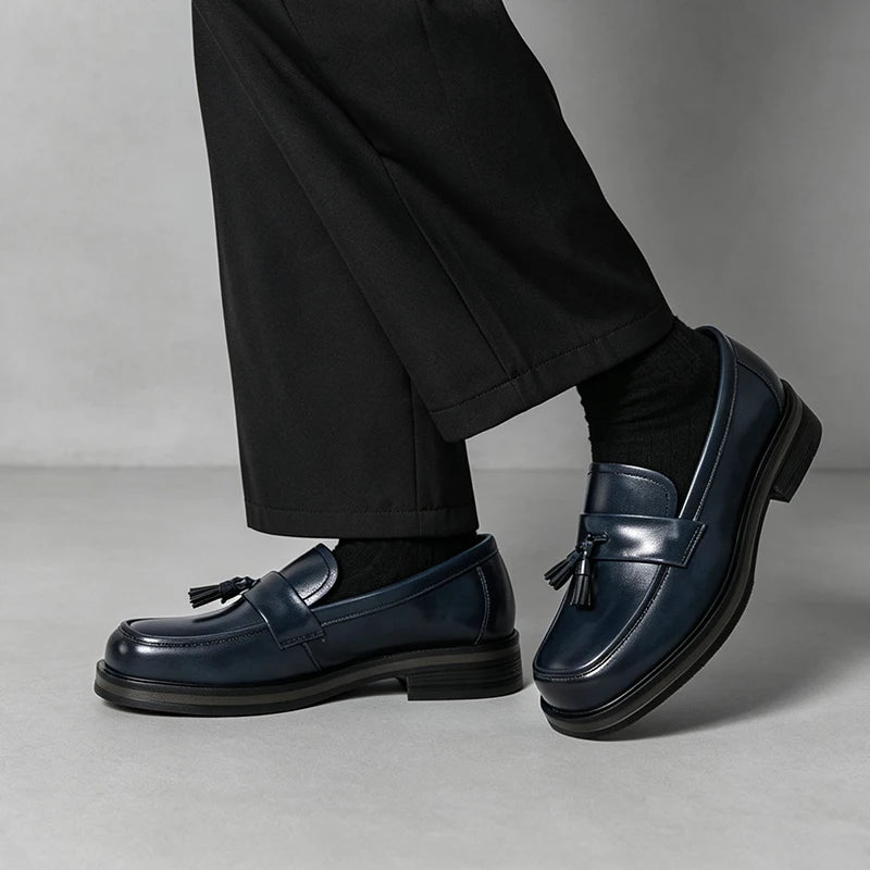 Man wearing navy blue tassel loafers with black trousers