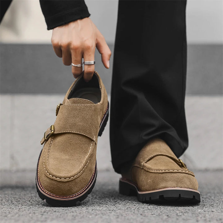 Model wearing khaki suede monk strap loafers, holding shoe