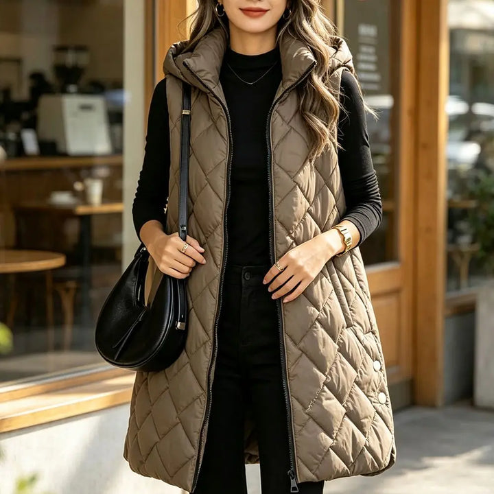Close up of coffee colored quilted puffer vest with hood on model