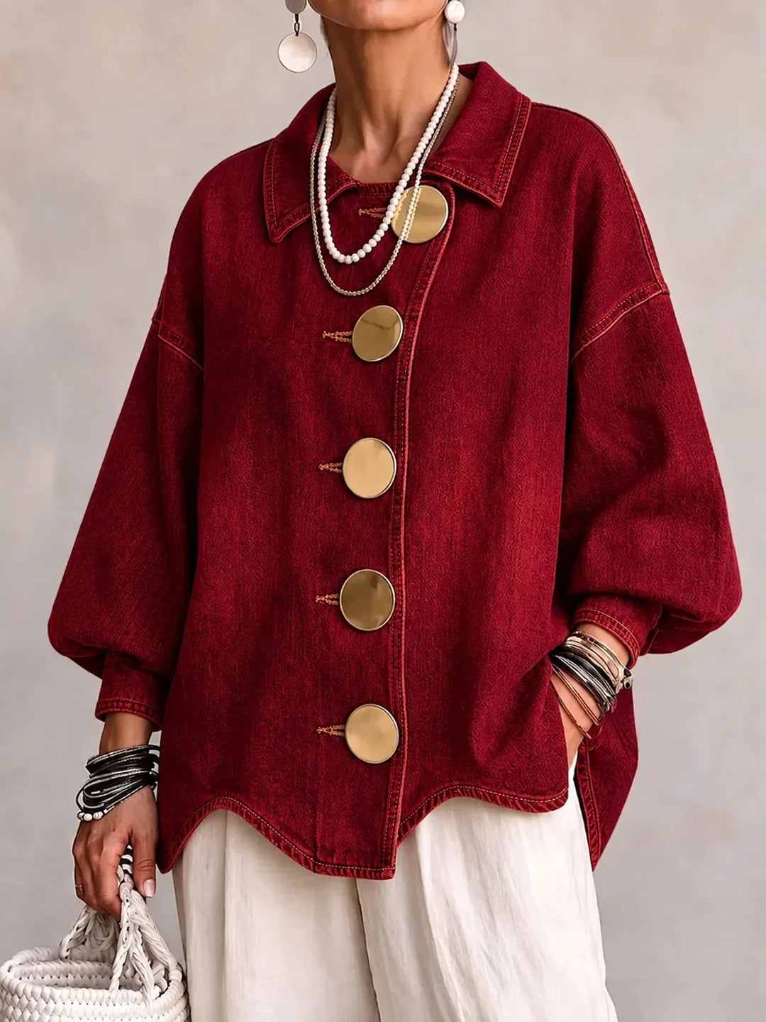 Woman wearing burgundy denim jacket with large gold buttons, front view