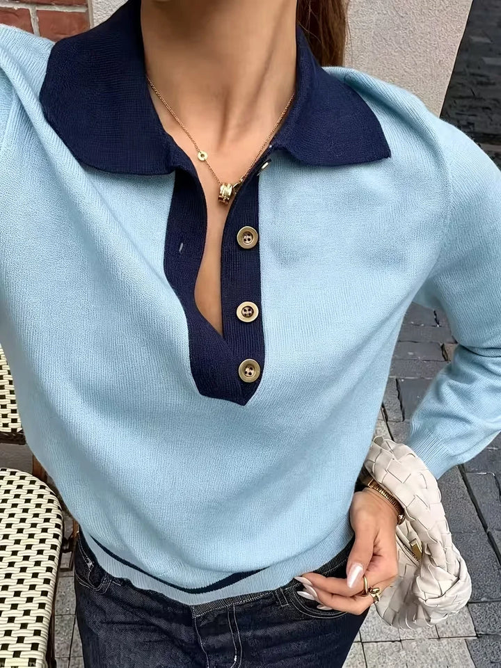 Close-up of sky blue polo sweater with contrast navy collar and buttons